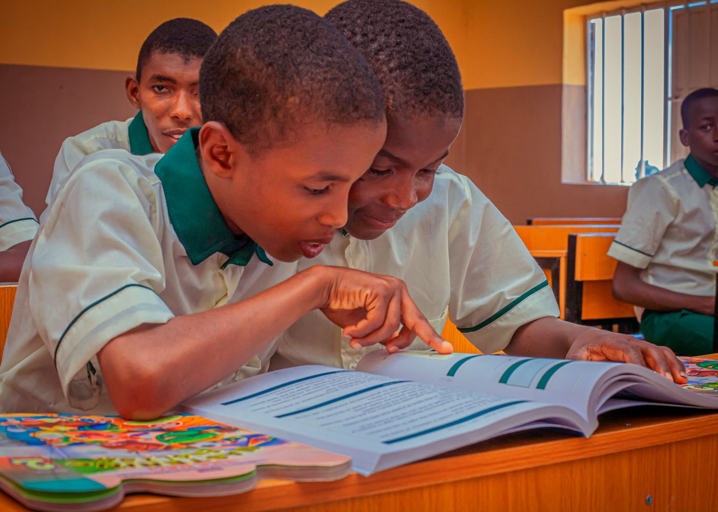 Two pupils reading a textbook together