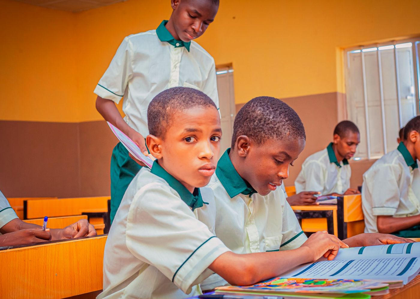 Junior secondary pupils in cream shirts with green collars